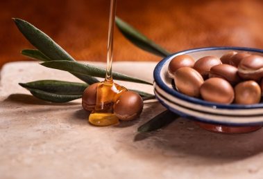 argan oil pouring over argan seeds